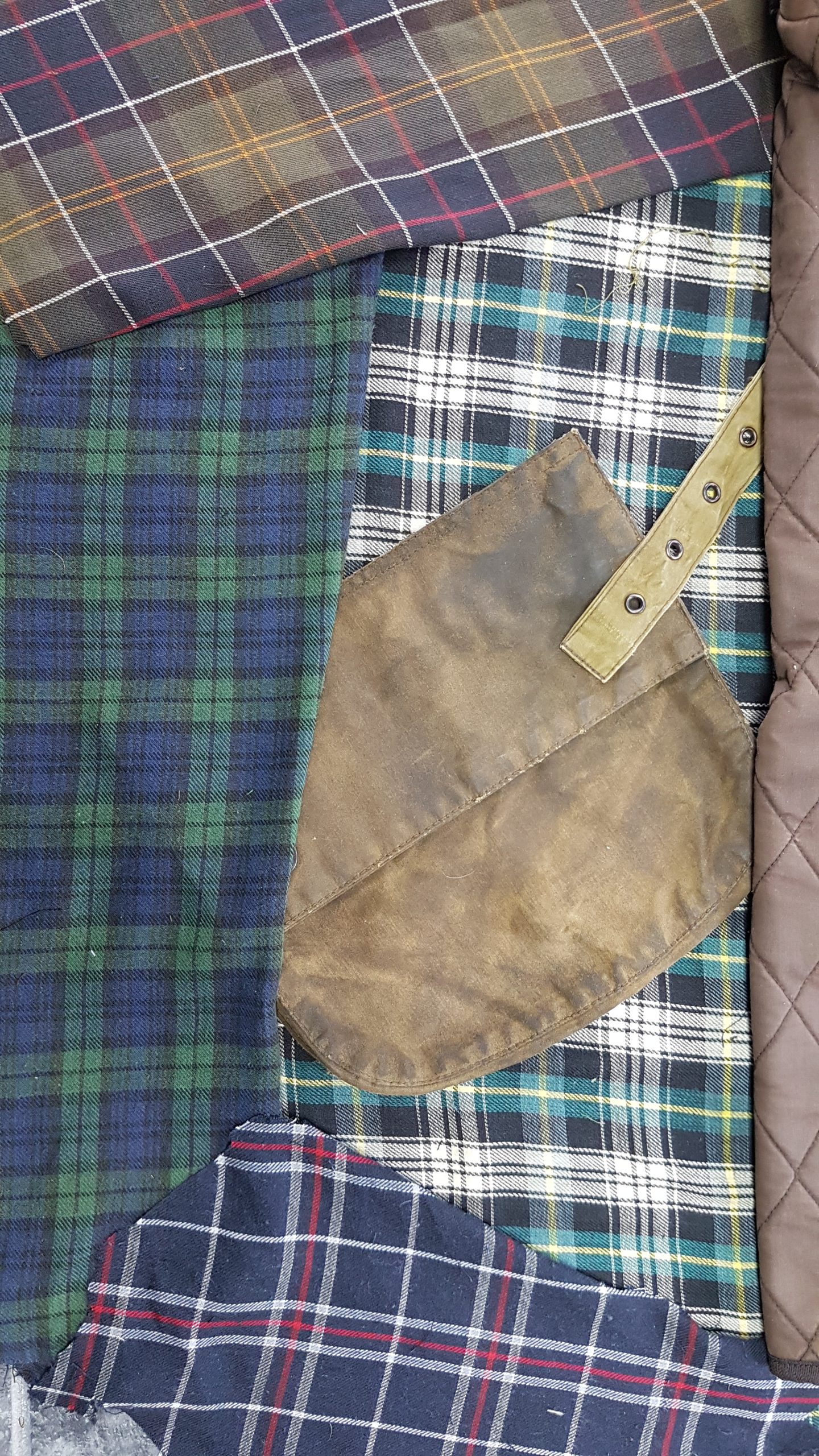 Vintage tartan and waxed cotton materials selected for Barbour jacket repairs